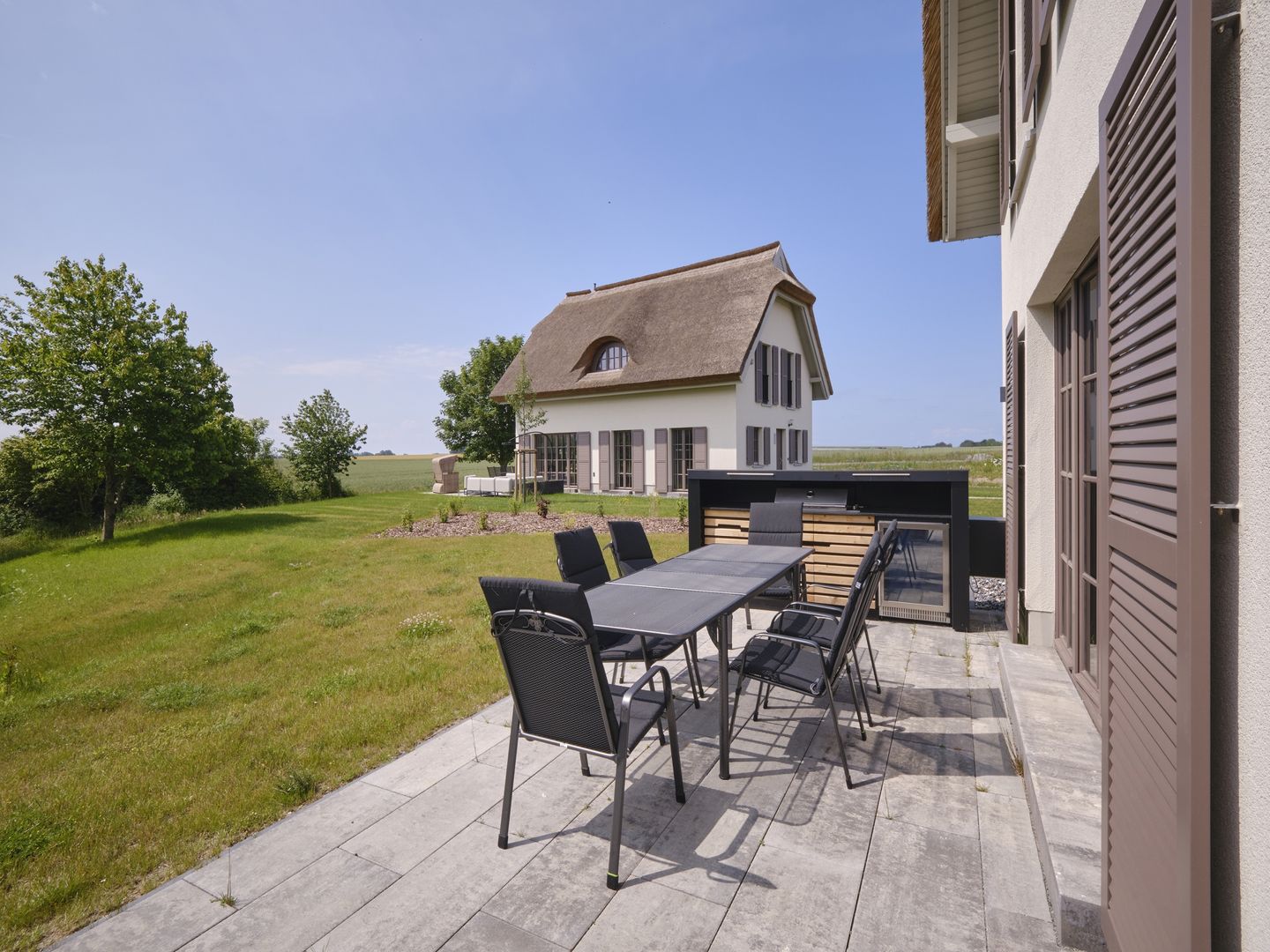 LuxusPlus Reetdachvilla mit 4 Schlafzimmern, Außensauna, Loungebereich und Kamin (H06) - Terrasse
