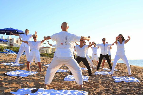 Menschen die am Strand Yoga praktizieren