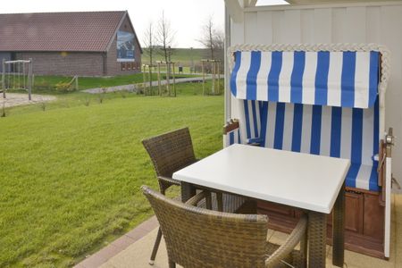 Resort Deichgraf Resort Deichgraf 27-01 Wremen - Terrasse mit Strandkorb und Sitzgelegenheit