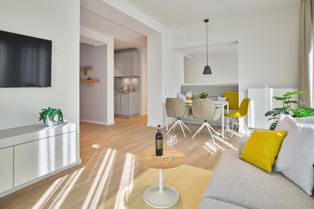 Lüttjeod Apartmentvilla Lüttjeod Apartmentvilla 02 Langeoog - Wohnbereich mit Couch, Esstisch und Sitzgelegenheit