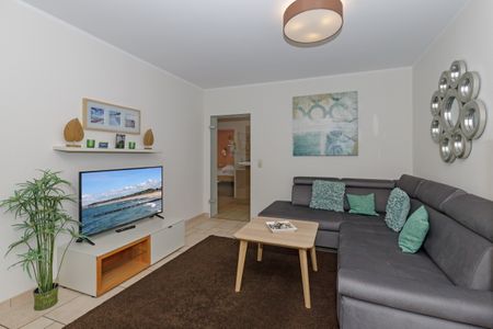Ostseeallee 32b Ostseeallee 32b 1-1 Kühlungsborn - Wohn-Essbereich mit Couch und Flatscreen-TV