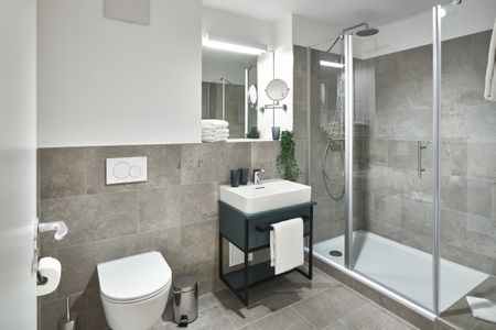 Lüttjeod Apartmentvilla Lüttjeod Apartmentvilla 03 Langeoog - Badezimmer mit Dusche, Waschtisch, WC und Spiegel