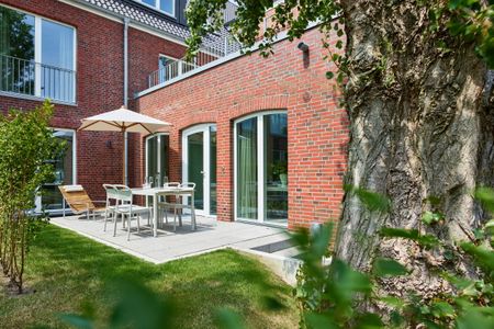 Lüttjeod Apartmentvilla Lüttjeod Apartmentvilla 03 Langeoog - Terrasse mit Gartenmöbeln und Grünfläche