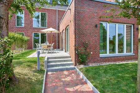 Lüttjeod Apartmentvilla Lüttjeod Apartmentvilla 03 Langeoog - Terrasse mit Gartenmöbeln und Grünfläche