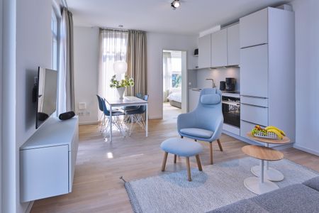 Lüttjeod Apartmentvilla Lüttjeod Apartmentvilla 08 Langeoog - Wohn-Essbereich mit Couch, Esstisch, Sitzgelegenheit und Küchenzeile