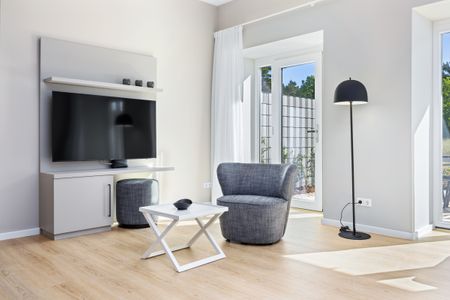 Strandresidenzen Binz-Prora Strandresidenzen Binz-Prora V0.1 Rügen - Wohn-Essbereich mit Couch und Flatscreen-TV
