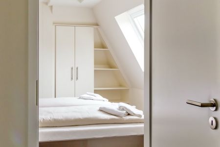 Resort Deichgraf Resort Deichgraf 27-18 Wremen - Schlafzimmer mit Doppelbett und Kleiderschrank