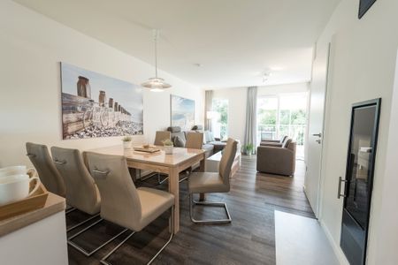 NordseeResort Friesland Ferienhäuser NordseeResort Friesland 38 Schillig - Wohn-Essbereich mit Esstisch und Sitzgelegenheit