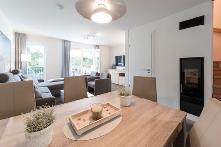 NordseeResort Friesland Ferienhäuser NordseeResort Friesland 38 Schillig - Wohn-Essbereich mit Esstisch und Sitzgelegenheit