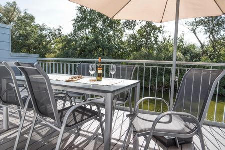 NordseeResort Friesland Ferienhäuser NordseeResort Friesland 38 Schillig - Balkon mit Gartenmöbeln am Wasser
