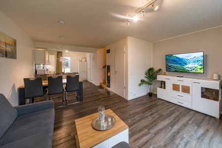 NordseeResort Friesland Ferienhäuser NordseeResort Friesland 11 Schillig - Wohn-Essbereich mit Couch und Flatscreen-TV