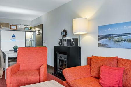 Resort Deichgraf Resort Deichgraf 27-10 Wremen - Wohnbereich mit Couch, Sesseln und Kamin