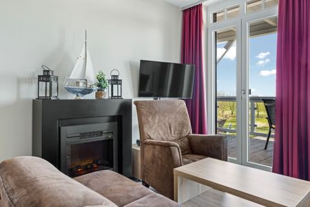 Resort Deichgraf Resort Deichgraf 27-14 Wremen - Wohnbereich mit Kamin und TV