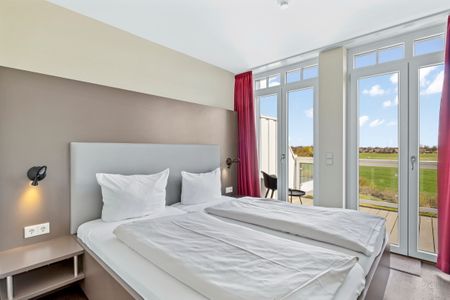 Resort Deichgraf Resort Deichgraf 27-18 Wremen - Schlafzimmer mit Doppelbett und Zugang zum Balkon