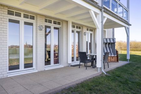Resort Deichgraf Resort Deichgraf 31-03 Wremen - Überdachte Terrasse mit Sitzgelegenheit und Strandkorb