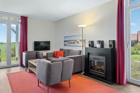Resort Deichgraf Resort Deichgraf 31-05 Wremen - Wohnzimmer mit Couch, Couchtisch, Sessel und Kamin
