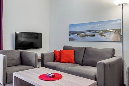 Resort Deichgraf Resort Deichgraf 31-05 Wremen - Wohnbereich mit Sofa, Sessel, Couchtisch und TV