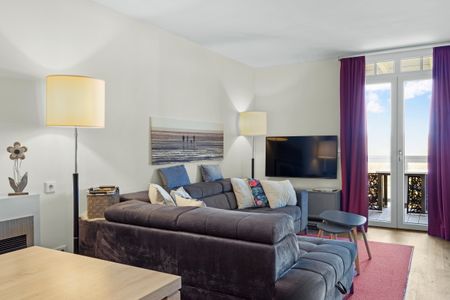 Resort Deichgraf Resort Deichgraf 31-07 Wremen - Wohnbereich mit Sofa, Couchtisch, TV und Zugang zum Balkon