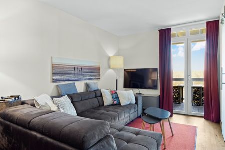 Resort Deichgraf Resort Deichgraf 31-07 Wremen - Wohnbereich mit Sofa, Couchtisch, TV und Zugang zum Balkon