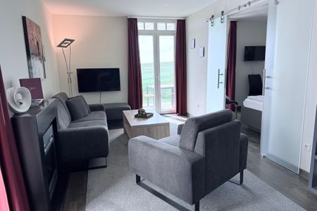 Resort Deichgraf Resort Deichgraf 31-04 Wremen - Wohn-Essbereich mit Couch und Flatscreen-TV