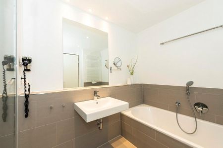 Apartmentvilla Anna See Apartmentvilla Anna See 1-03 Langeoog - Badezimmer mit Badewanne, Waschtisch und Spiegel
