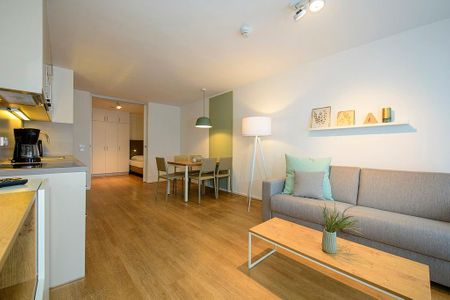 Apartmentvilla Anna See Apartmentvilla Anna See 1-14 Langeoog - Wohn-Essbereich mit Couch, Esstisch und Sitzgelegenheit