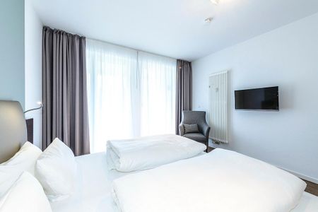 Deichhäuser Anna Küste Deichhäuser Anna Küste 1-11 Bensersiel - Schlafzimmer mit Doppelbett, Sessel und TV