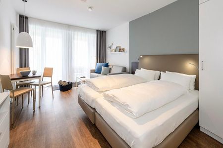 Deichhäuser Anna Küste Deichhäuser Anna Küste 1-22 Bensersiel - Wohn/Essbereich mit Doppelbett, Esstisch und Couch
