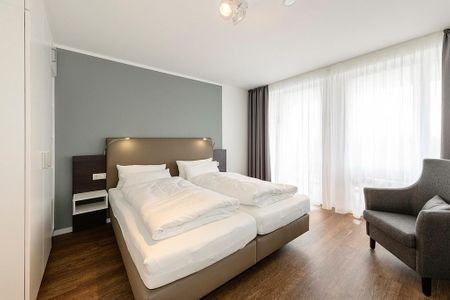 Deichhäuser Anna Küste Deichhäuser Anna Küste 1-31 Bensersiel - Schlafzimmer mit Doppelbett, Sessel und Kleiderschrank
