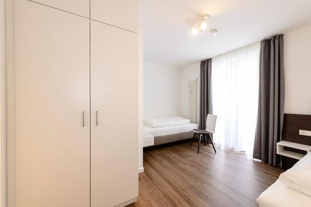 Deichhäuser Anna Küste Deichhäuser Anna Küste 1-34 Bensersiel - Schlafzimmer mit zwei Einzelbetten, Stuhl und Kleiderschrank