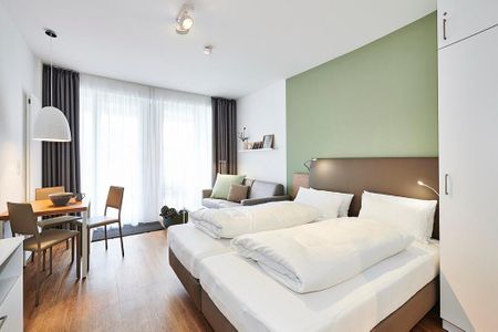 Deichhäuser Anna Küste Deichhäuser Anna Küste 2-12 Bensersiel - Wohn/Essbereich mit Doppelbett, Esstisch und Couch