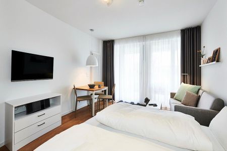 Deichhäuser Anna Küste Deichhäuser Anna Küste 2-12 Bensersiel - Wohn/Essbereich mit Doppelbett, Couch, Esstisch und TV