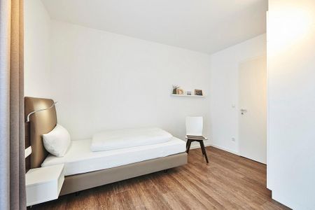 Deichhäuser Anna Küste Deichhäuser Anna Küste 2-14 Bensersiel - Schlafzimmer mit zwei Einzelbetten und Stuhl