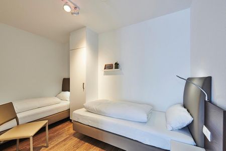 Deichhäuser Anna Küste Deichhäuser Anna Küste 2-21 Bensersiel - Schlafzimmer mit zwei Einzelbetten, Stuhl und Kleiderschrank