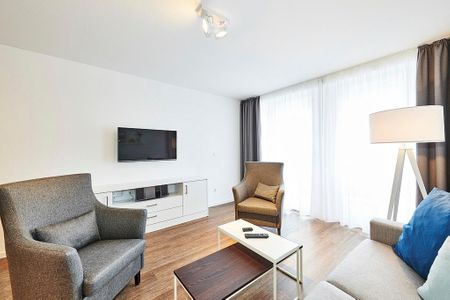 Deichhäuser Anna Küste Deichhäuser Anna Küste 2-30 Bensersiel - Wohn/Essbereich mit Sesseln, Couch und TV