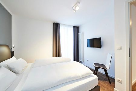 Deichhäuser Anna Küste Deichhäuser Anna Küste 2-30 Bensersiel - Schlafzimmer mit Doppelbett, Stuhl und TV
