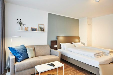 Deichhäuser Anna Küste Deichhäuser Anna Küste 2-32 Bensersiel - Wohn/Essbereich mit Couch, Doppelbett und Kleiderschrank
