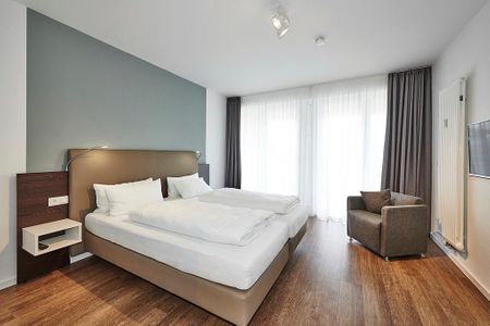 Deichhäuser Anna Küste Deichhäuser Anna Küste 3-11 Bensersiel - Schlafzimmer mit Doppelbett und Sessel