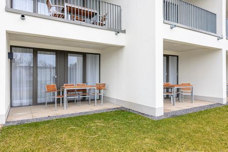 Deichhäuser Anna Küste Deichhäuser Anna Küste 4-11 Bensersiel - Überdachte Terrasse mit Sitzgelegenheit und Grünfläche