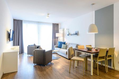 Deichhäuser Anna Küste Deichhäuser Anna Küste 4-20 Bensersiel - Wohn-Essbereich mit Couch, Sessel, Esstisch und Zugang zum Balkon