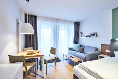 Deichhäuser Anna Küste Deichhäuser Anna Küste 4-22 Bensersiel - Wohn-Ess-Schlafbereich mit Sofa, Esstisch, Sitzgelegenheit und Doppelbett sowie Zugang zum Balkon