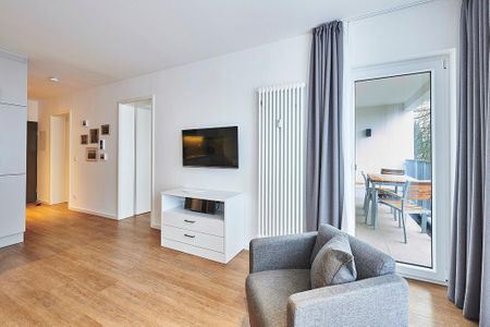 Deichhäuser Anna Küste Deichhäuser Anna Küste 4-24 Bensersiel - Wohnbereich mit Flatscreen-TV und Zugang zum Balkon