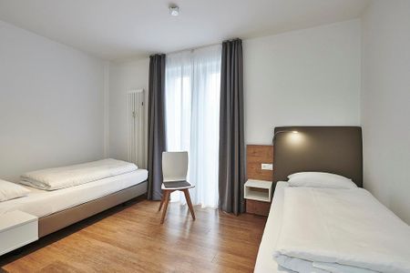 Deichhäuser Anna Küste Deichhäuser Anna Küste 4-24 Bensersiel - Schlafzimmer mit zwei Einzelbetten und Sitzgelegenheit