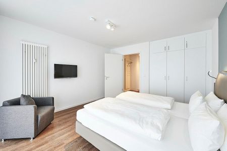 Deichhäuser Anna Küste Deichhäuser Anna Küste 4-31 Bensersiel - Schlafzimmer mit Doppelbett, Kleiderschrank, Sessel und Flatscreen TV