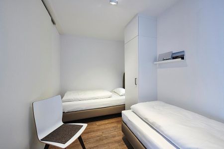 Deichhäuser Anna Küste Deichhäuser Anna Küste 4-31 Bensersiel - Schlafzimmer mit zwei Einzelbetten, Kleiderschrank und Stuhl