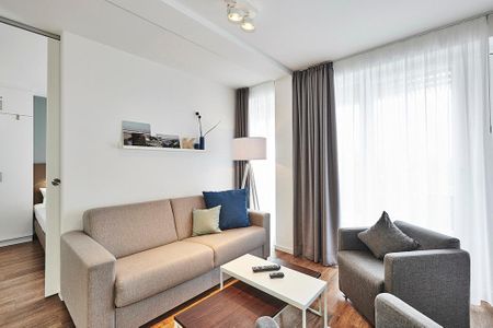 Deichhäuser Anna Küste Deichhäuser Anna Küste 4-33 Bensersiel - Wohnbereich mit Sofa, Sessel, Couchtisch und Zugang zum Balkon