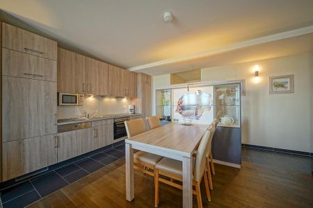 Resort Deichgraf Resort Deichgraf 27-21 Wremen - Wohn-Essbereich mit Esstisch, Sitzgelegenheit und Küchenzeile