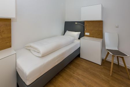 Deichhäuser Anna Küste Deichhäuser Anna Küste 6-11 Bensersiel - Schlafzimmer mit zwei Boxspringbetten und Stuhl