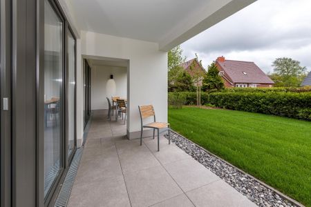 Deichhäuser Anna Küste Deichhäuser Anna Küste 6-13 Bensersiel - Überdachte Terrasse mit Sitzgelegenheit und Grünfläche