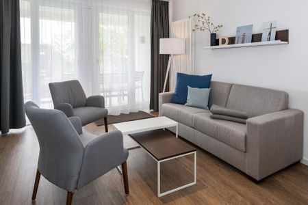 Deichhäuser Anna Küste Deichhäuser Anna Küste 6-20 Bensersiel - Wohn-Essbereich mit Couch und Zugang zum Balkon
